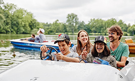 Gruppe sitzt lachend in einem Tretboot
